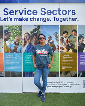 Volunteer standing in front of sign